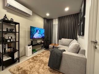 Modern living room with sectional sofa and wall-mounted TV