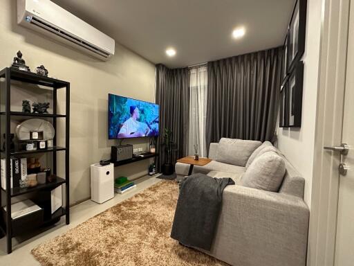 Modern living room with sectional sofa and wall-mounted TV