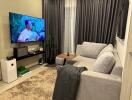 Modern living room with a gray sofa and a large TV