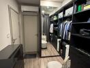 Spacious walk-in closet with modern black shelving and full-length mirror