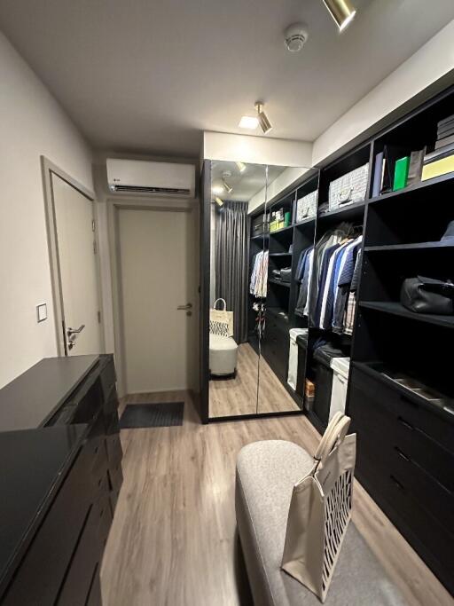 Spacious walk-in closet with modern black shelving and full-length mirror