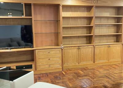 Living room with built-in wooden shelves and TV