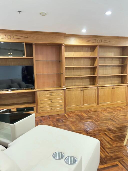 Living room with built-in wooden shelves and TV