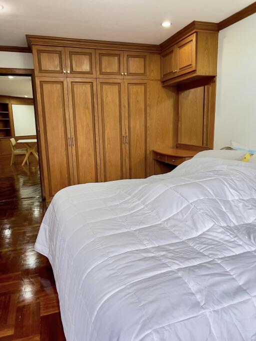 spacious bedroom with wooden built-in wardrobes