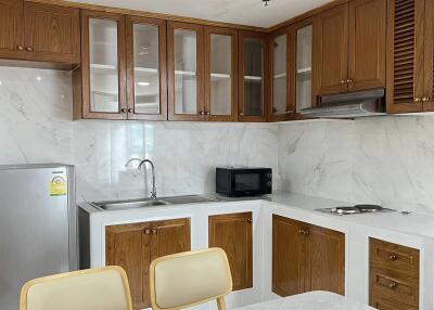 Modern kitchen with wooden cabinetry and white marble countertops