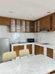 Modern kitchen with wooden cabinetry and white marble countertops