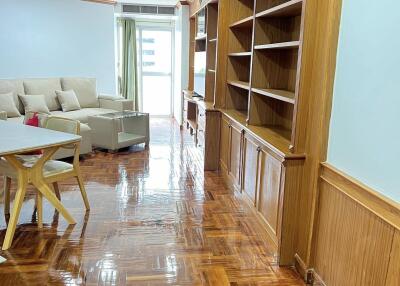 Living room with wooden flooring and built-in shelves