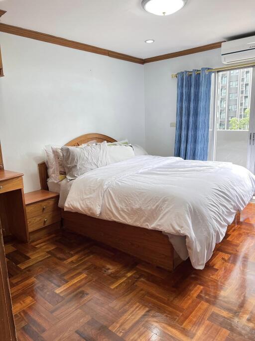 Spacious and bright bedroom with wooden furniture and a large bed