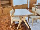 Dining area with table and chairs, wooden flooring and built-in bookshelves