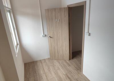 Small room with wooden flooring and a door marked 