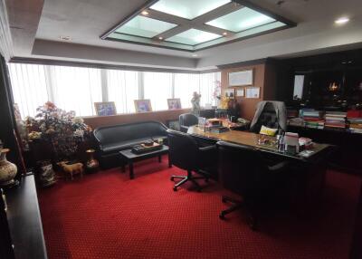 Spacious and well-lit office with red carpet flooring.