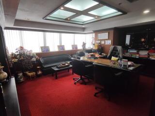 Spacious and well-lit office with red carpet flooring.