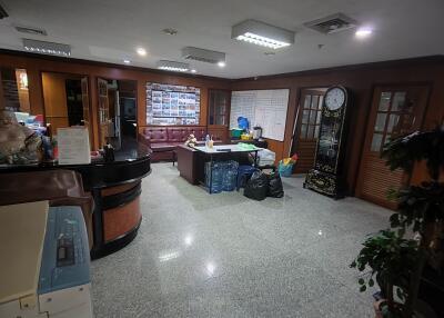 Building lobby with seating area, reception desk, and large clock