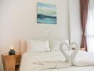 Bedroom with decorative towel swans and minimalistic decor