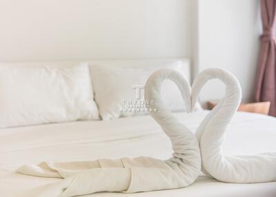 Cozy bedroom with white bed and towel swans