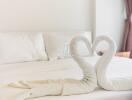 Cozy bedroom with white bed and towel swans