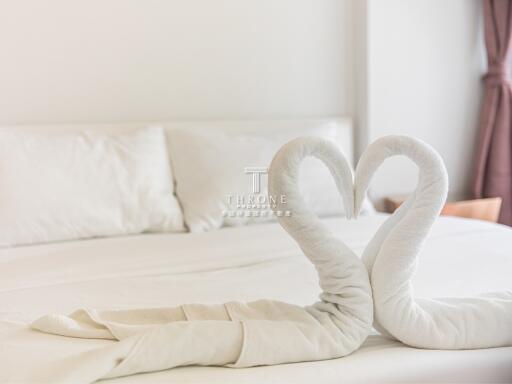 Cozy bedroom with white bed and towel swans