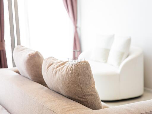 Cozy living room with a beige sofa and a white armchair