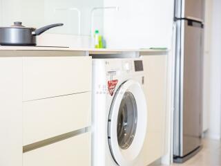 Modern kitchen with a washing machine and refrigerator