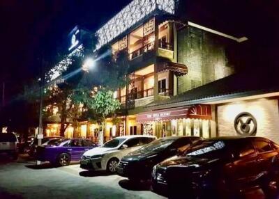 Exterior view of a building with cars parked in front at night