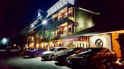 Exterior view of a building with cars parked in front at night