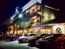 Exterior view of a building with cars parked in front at night