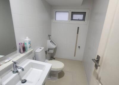 A small, modern bathroom with a sink, toilet, and a bidet.