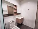 Modern bathroom with sink, mirror cabinet, and toilet