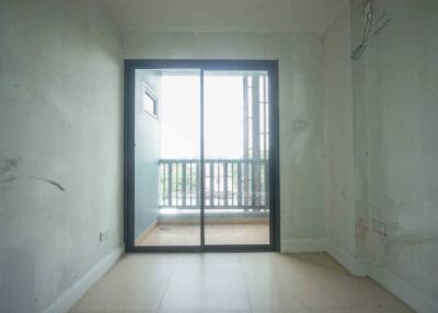 View of an empty room leading to a balcony through glass sliding doors