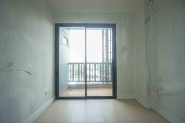 View of an empty room leading to a balcony through glass sliding doors