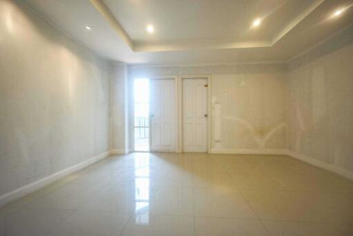 Spacious empty living room with tile flooring and recessed lighting