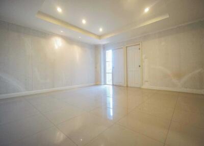 Spacious empty living room with tiled floor and recessed lighting