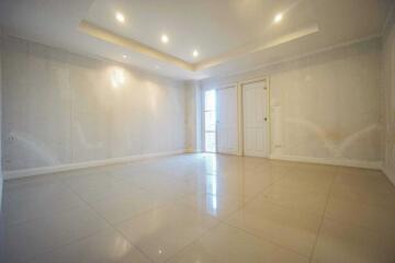 Spacious empty living room with tiled floor and recessed lighting