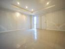 Spacious empty living room with tiled floor and recessed lighting