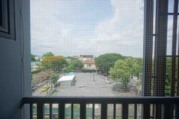 View from the balcony overlooking a parking area and greenery