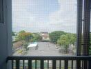 View from the balcony overlooking a parking area and greenery