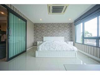 Modern bedroom with large windows and white furniture