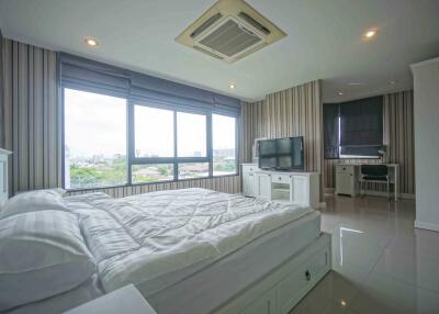 Modern bedroom with large window, double bed, and TV