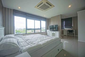 Modern bedroom with large window, double bed, and TV