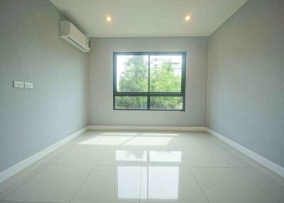 Empty bedroom with large window, air conditioning unit, and tiled floor