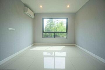 Empty bedroom with large window, air conditioning unit, and tiled floor