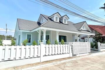 Front view of a modern house with a white fence