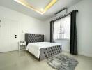 Modern bedroom with gray padded bed and white bedding