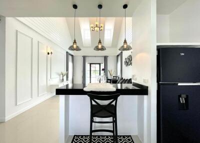 Modern white kitchen with black accents and a breakfast bar