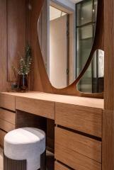 Modern bedroom vanity area with wooden drawers and unique mirror design