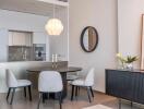 Modern dining area with round table, chairs, and kitchen in background