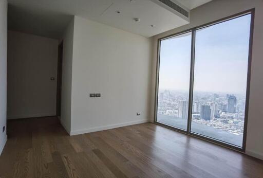 Spacious bedroom with large window offering city view