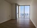 empty room with large floor-to-ceiling window and city view