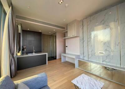 Modern living area with kitchenette and marble accent wall