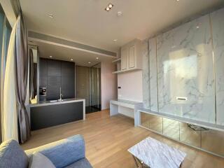 Modern living area with kitchenette and marble accent wall